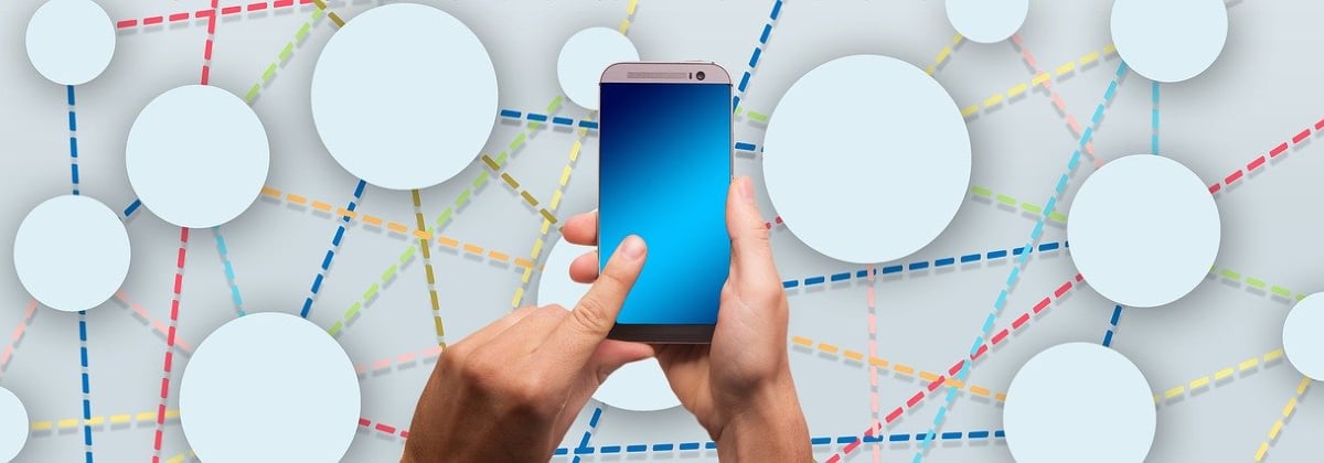 Hands touching a smartphone in front of a in front of a web map background