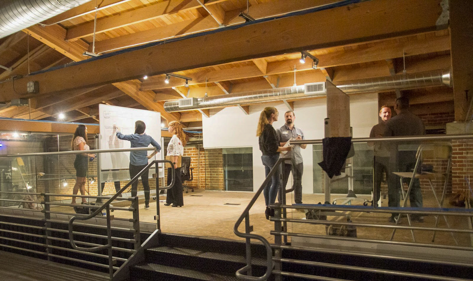 Photo courtesy of SDXD. Participants in the Interview Olympics show off their whiteboarding skills in the (unfinished at the time) collaboration zone on top of the user research labs.