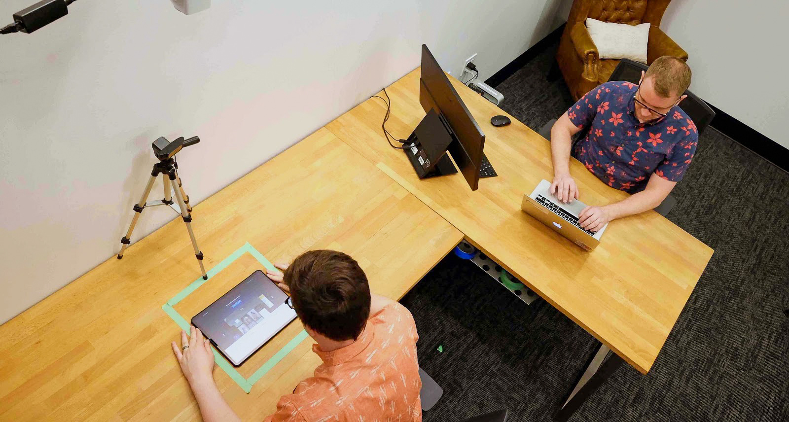 A study participant uses an application while a researcher observes and takes notes.