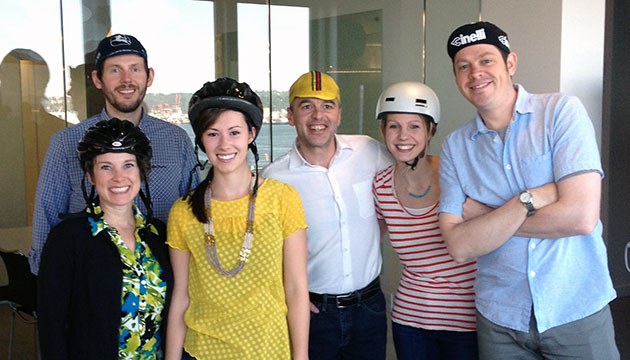 A group of Blink team members posing while wearing bicycle helmets and hats