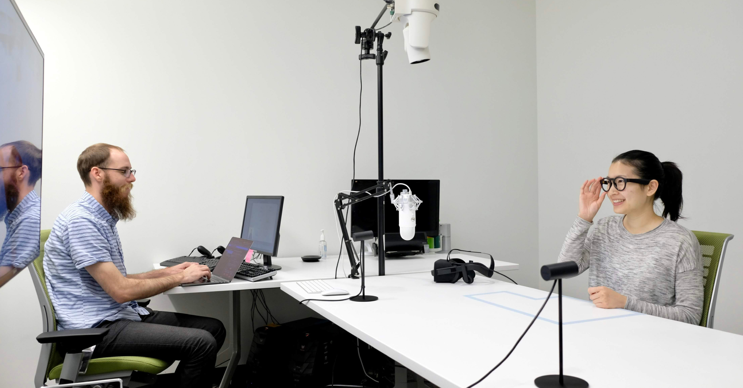 A researcher conducting an in-person usability interview with a participant for VR glasses