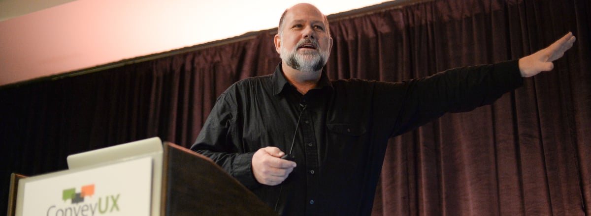 Man talking at a podium at ConveyUX conference