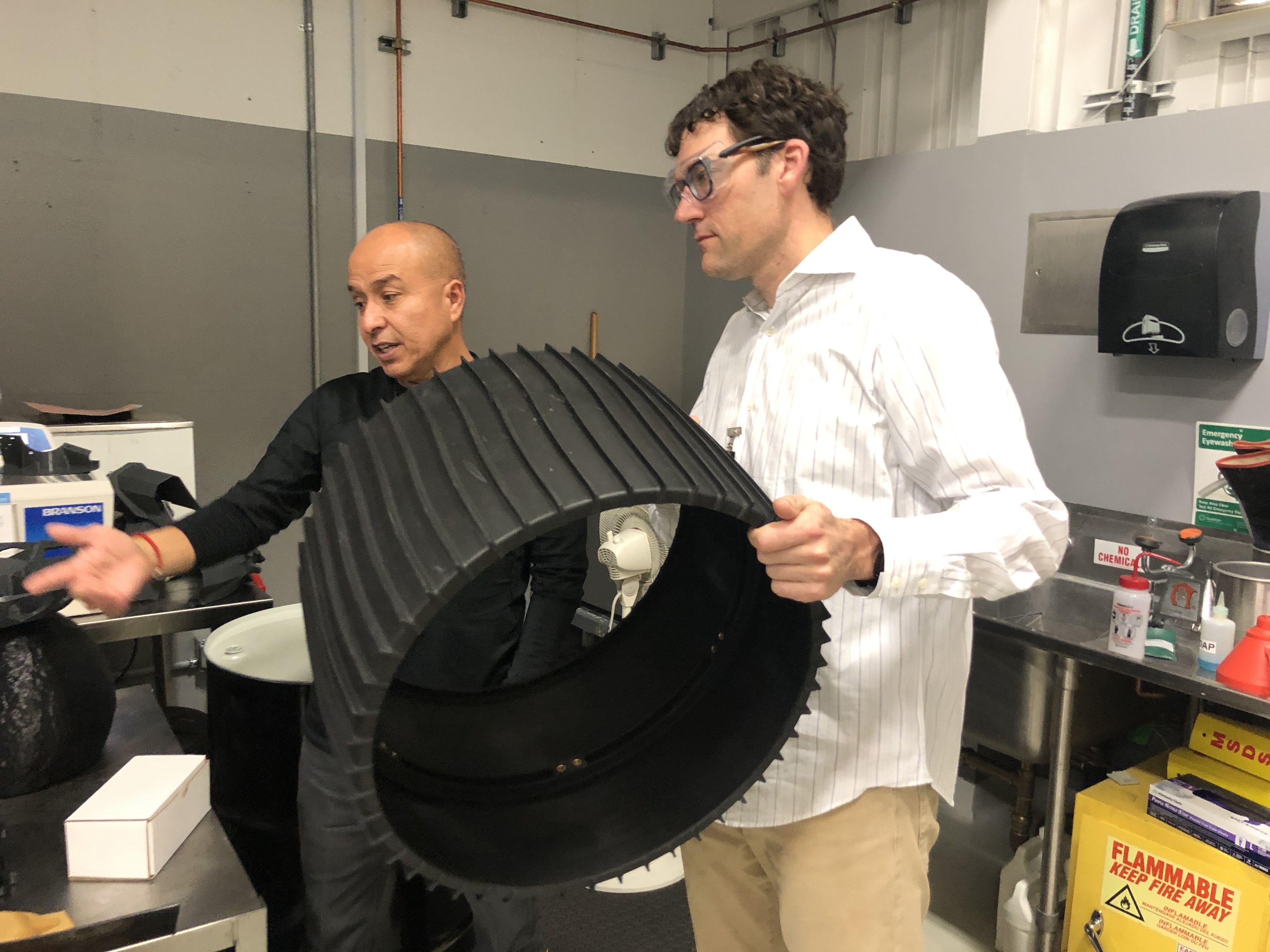 Geoff holding a rubber tire in a machine shop