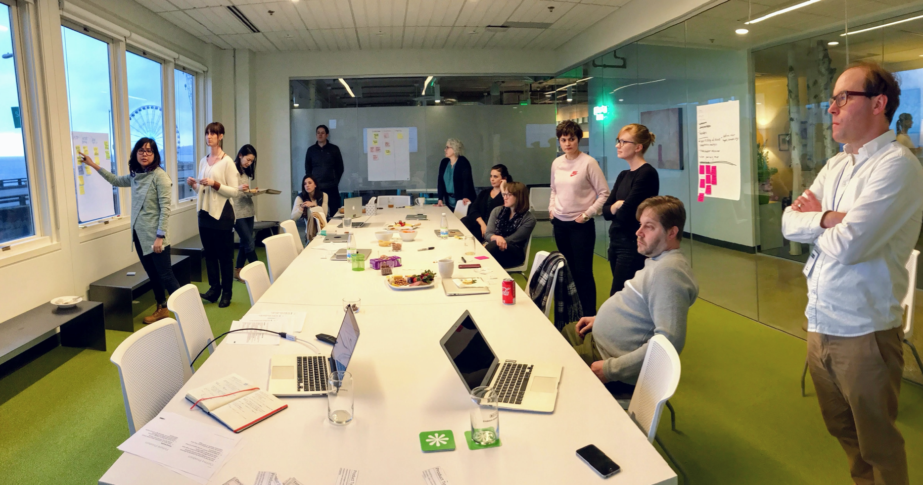Is collaboration a thing of the past? Photo of group of people in a room working together. Really nice green carpet and view of Bell Harbor