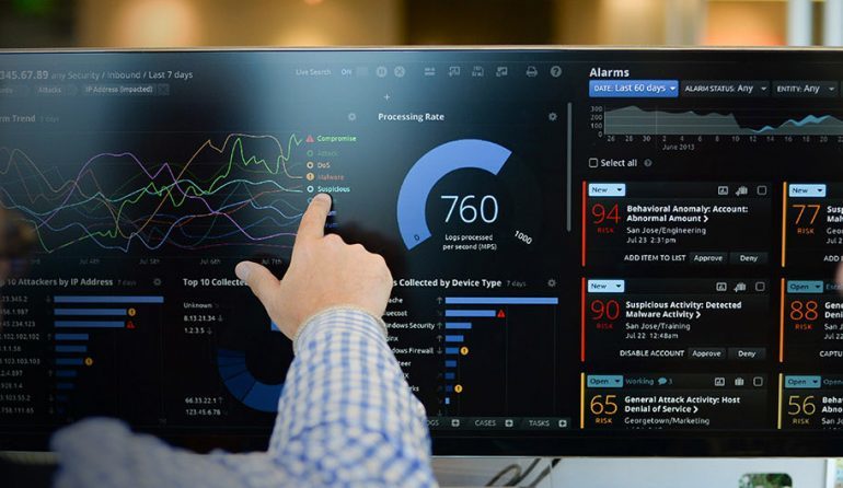 A photo of a person pointing to the dashboard information panel for an enterprise software application.