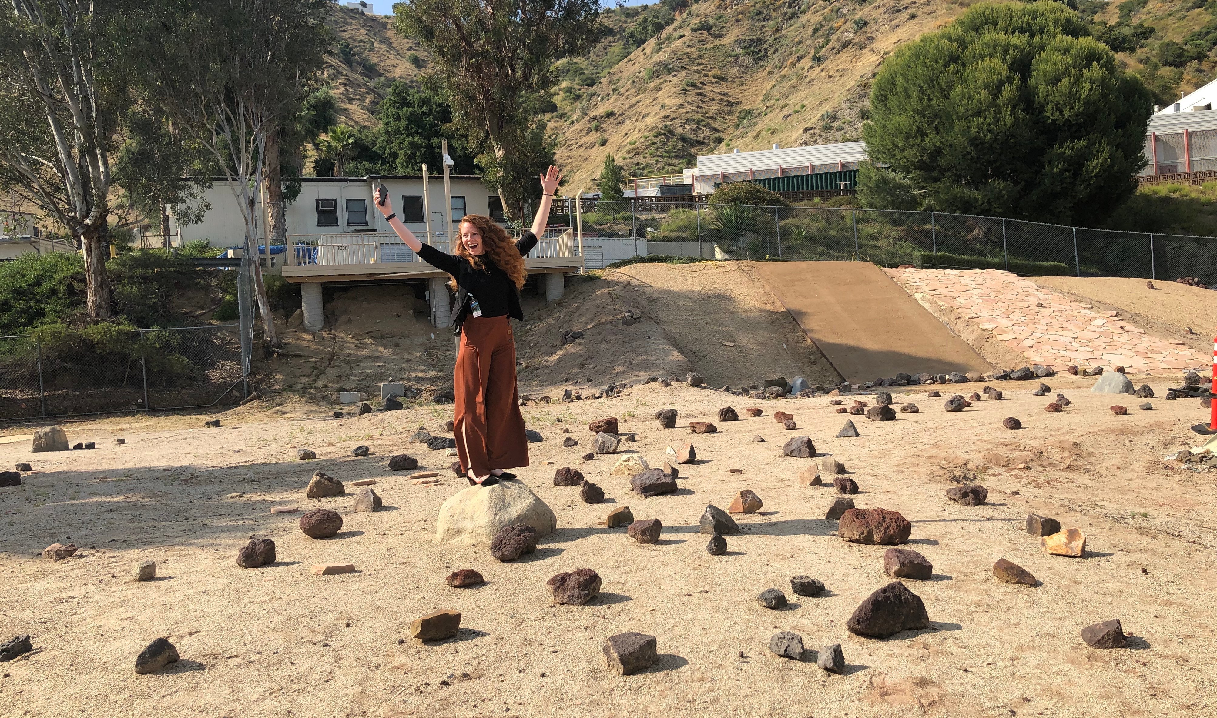 Woman standing on a rock in JPL's Mars yard rover testing location.