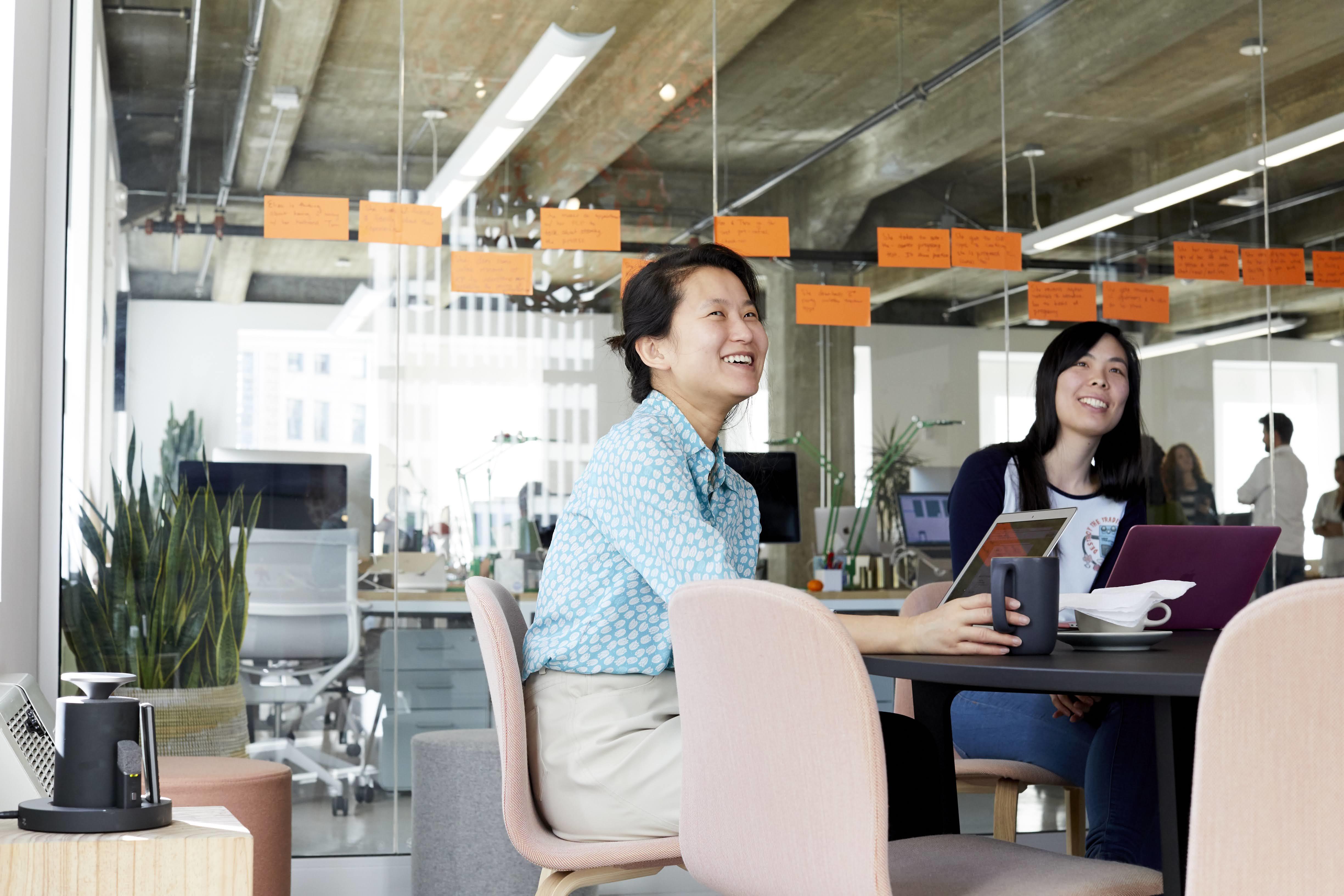 Two women smiling in a conference room at Blink's San Francisco studio.