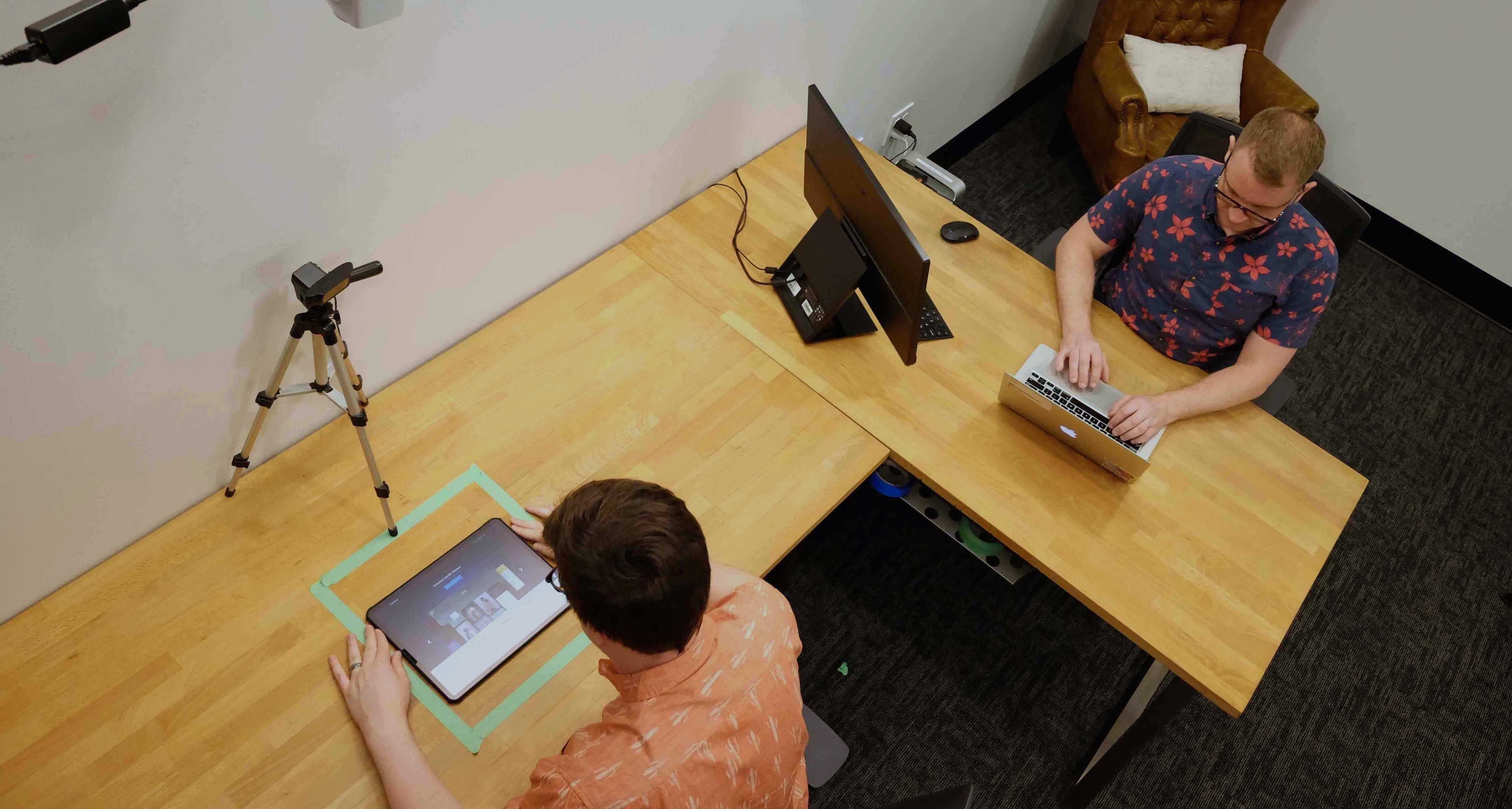 Aerial view of two people working in a usability testing lab.