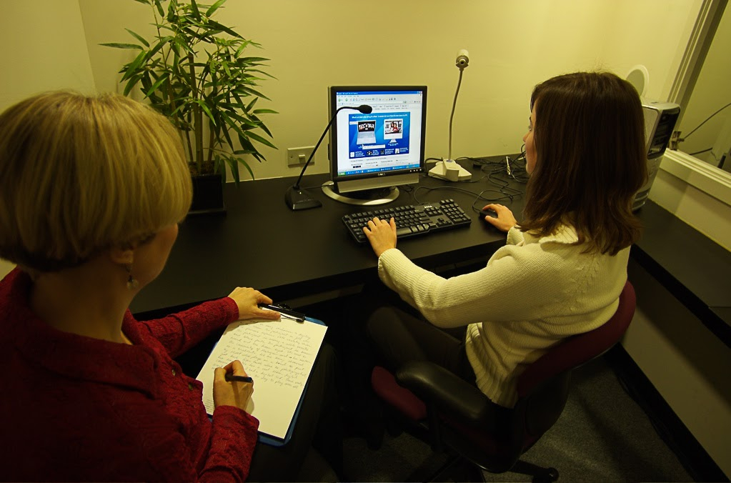Woman taking notes next to a usability test participant.