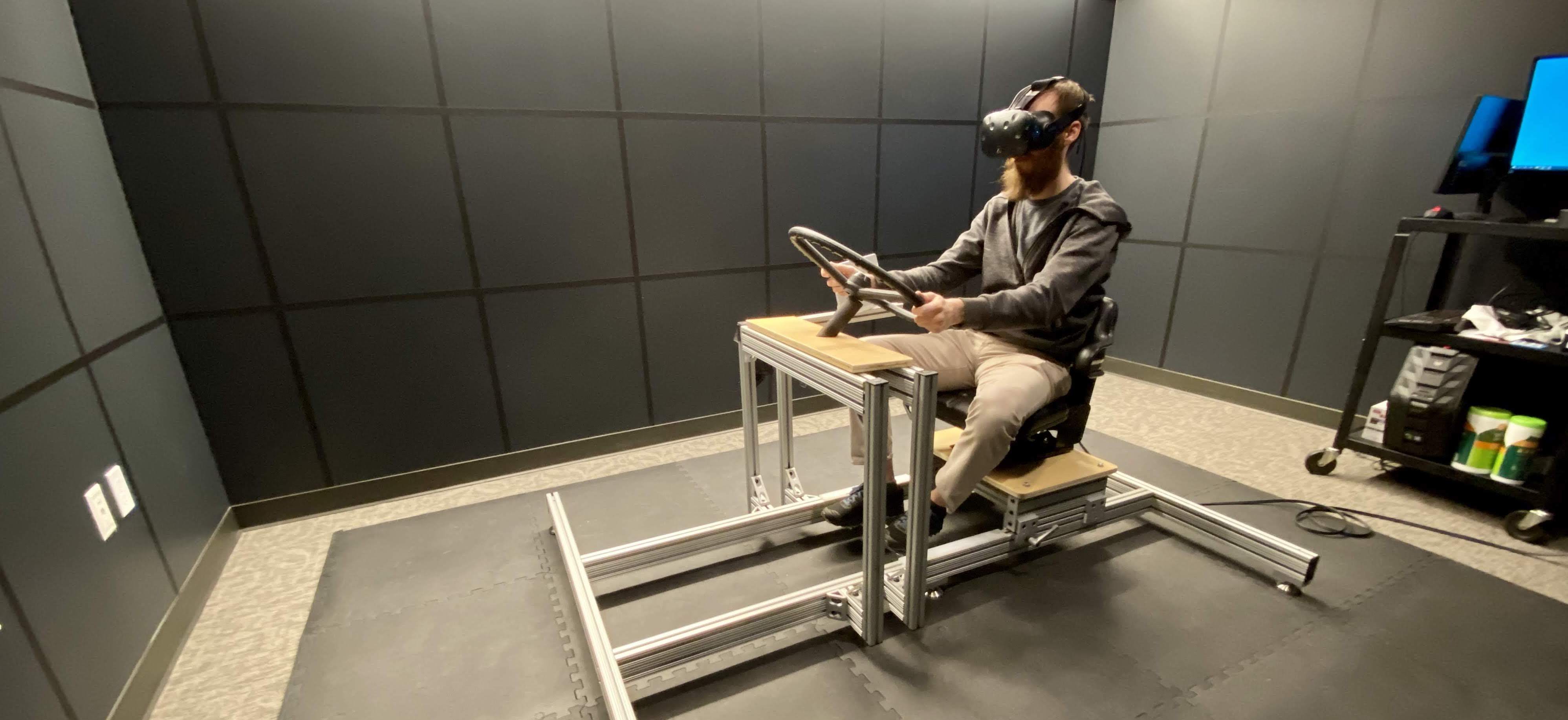 Man testing a virtual reality driving simulator.