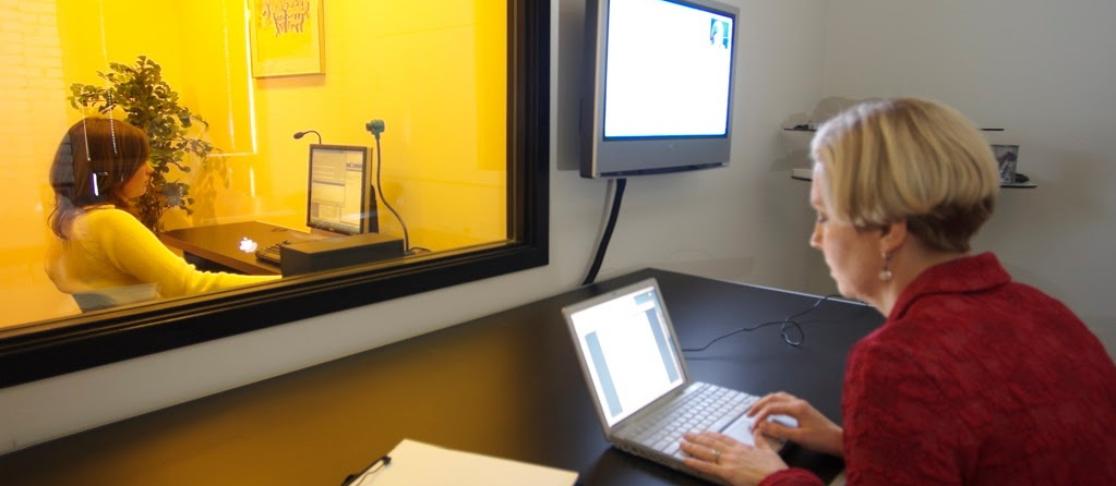 Participant behind a glass window undergoing user experience testing.