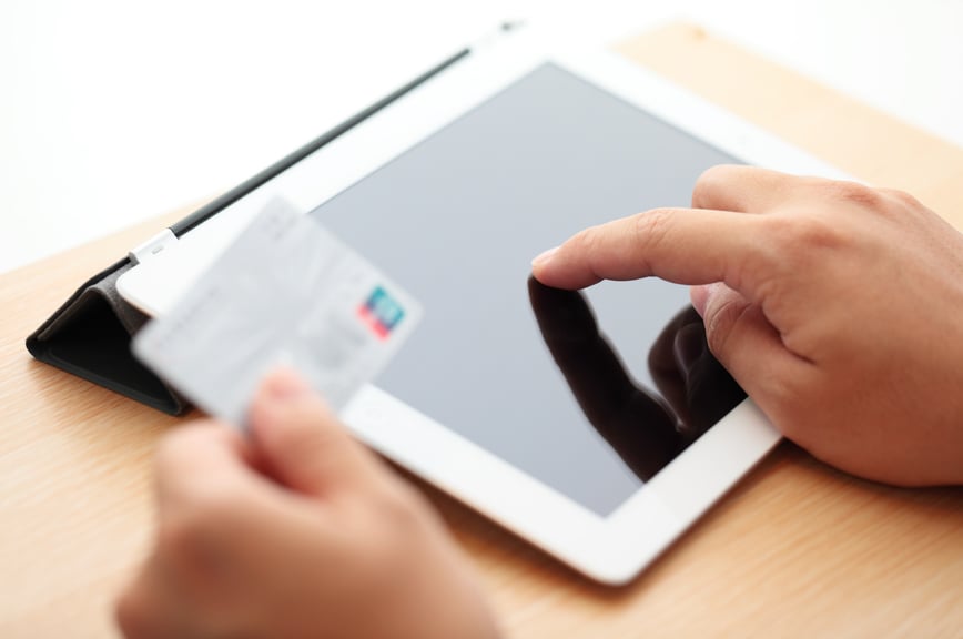 Person entering credit card information into tablet.