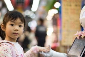 Little girl holding hands with a robot