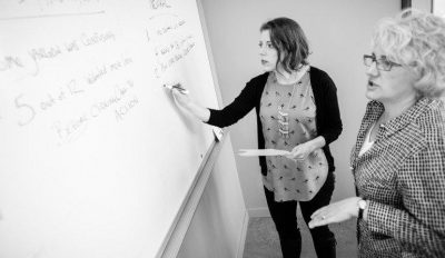 Two Blink researchers plan a debrief on a whiteboard