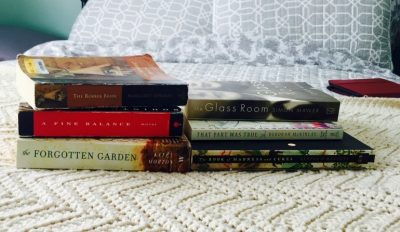 A photo of 2 stacks of soft cover books