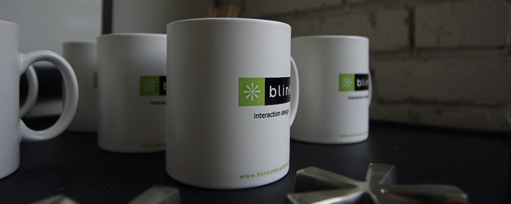 White coffee mugs with Blink logos on them.