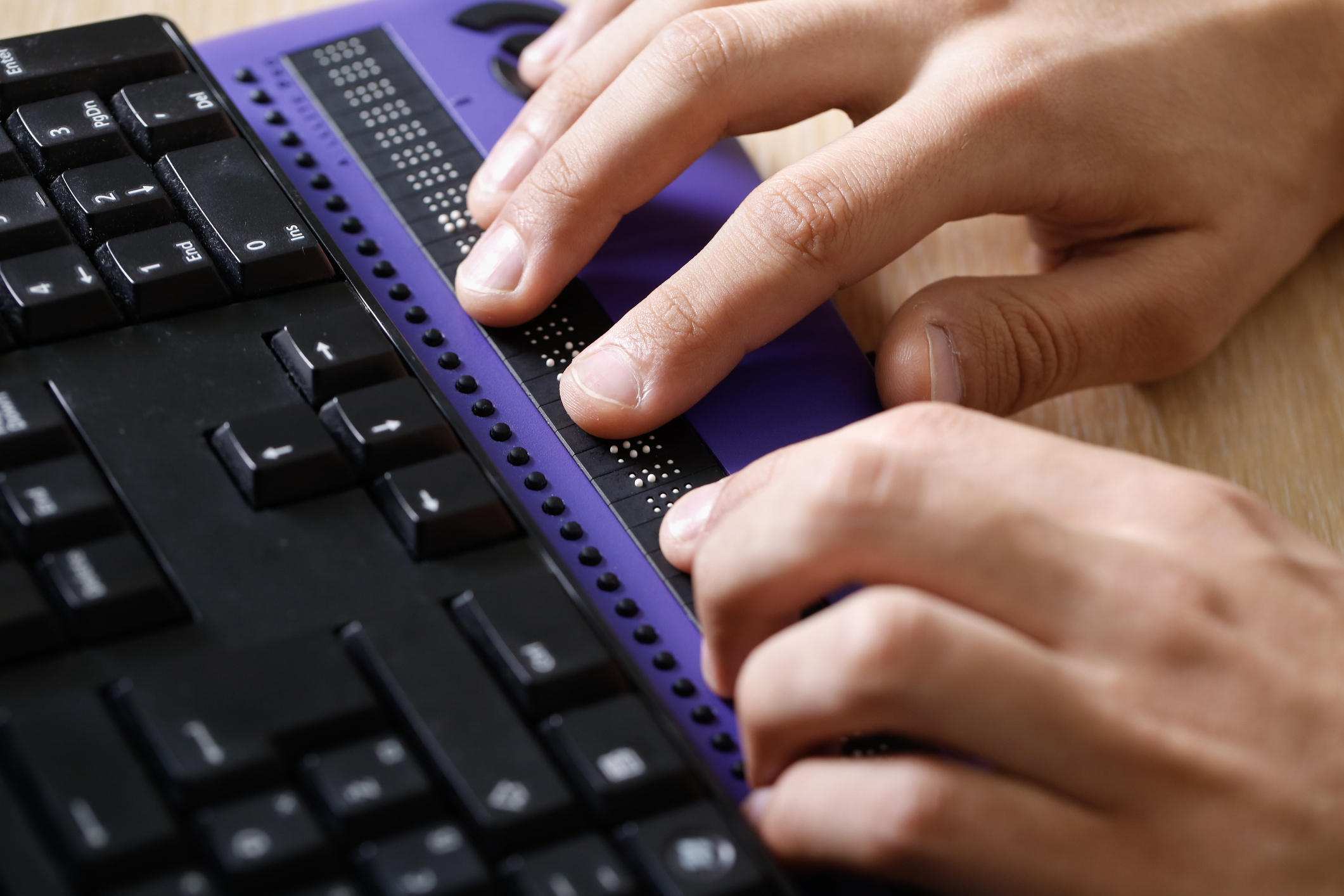 Person typing with a braille keyboard.