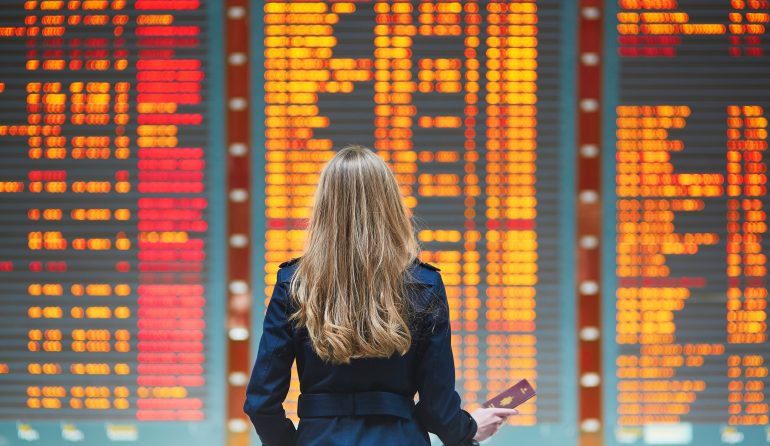 A photo of woman standing in front of an airport directory