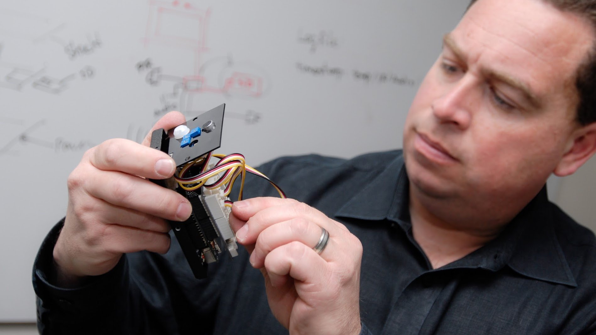 Man holding an Internet of Things (IoT) device.