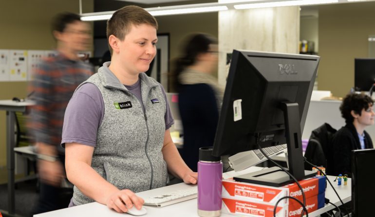 A photo of the article author, Katie Greiner, at a computer workstation.
