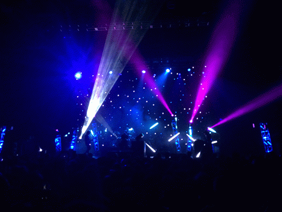 Lights shining as M83 performs on stage.