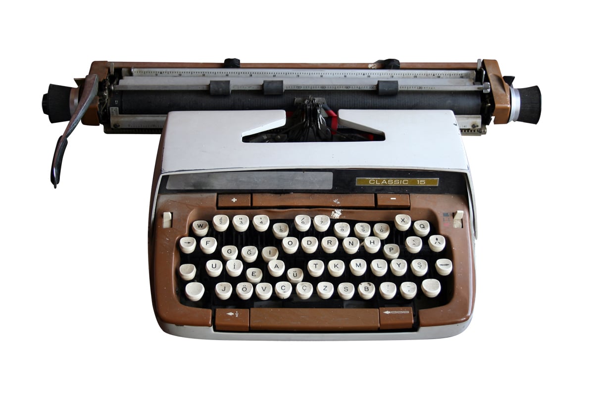 Top-down view of brown typewriter with white keys.