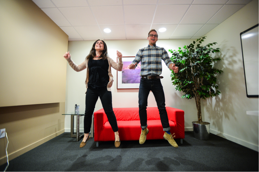 Two Blink employees jumping while playing with an Xbox gaming console.